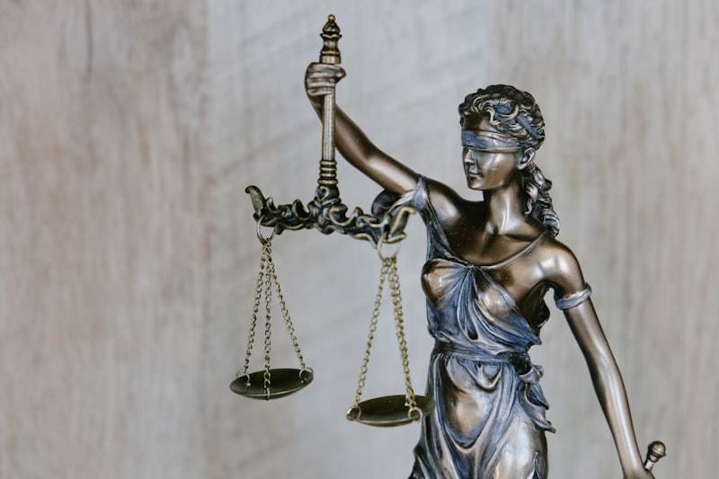 A figure of Justice holding balanced scales and a sword