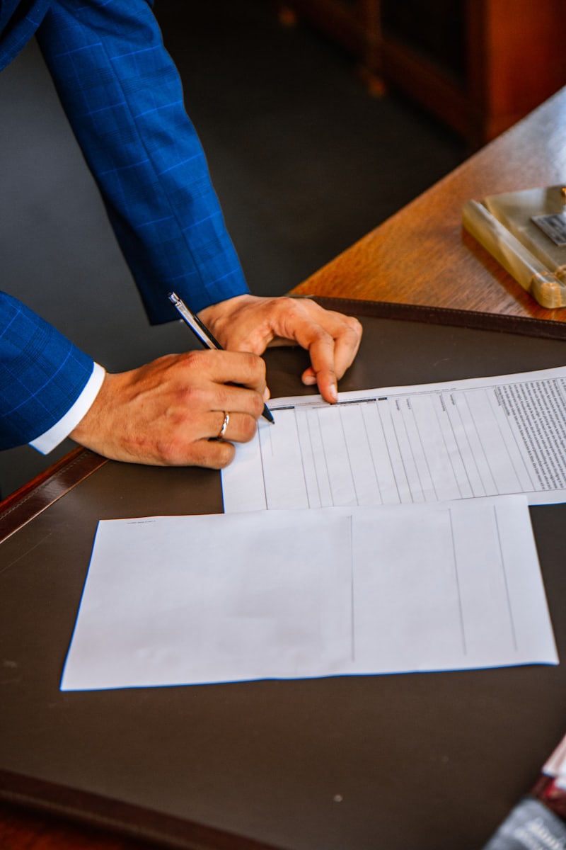 A hand completing a printed form